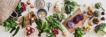 Table with fresh seasonal vegetables, greens, fruit from grocery marketの写真素材