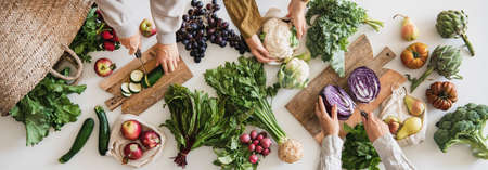 Female hands cutting various veggies and fruits, top viewの写真素材