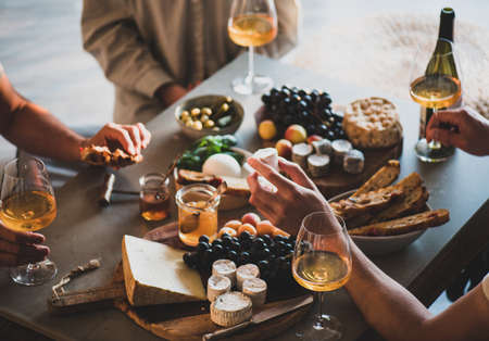 People drinking orange wine eating tasty snacksの写真素材