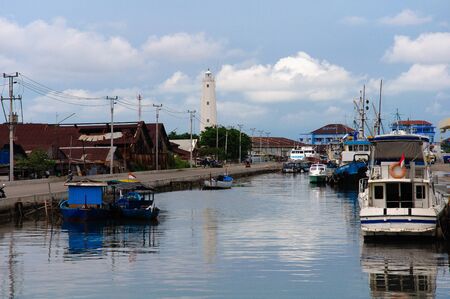 some of the boats and ship in the seaport with ancient lighthouseのeditorial素材