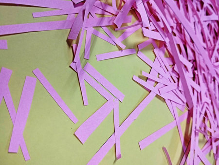 Purple paper pieces on a green background.の写真素材