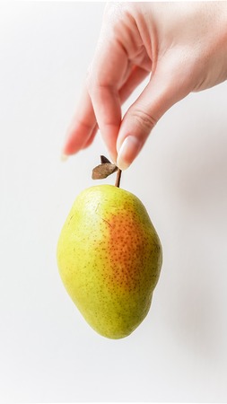 Ripe green pear in handの写真素材