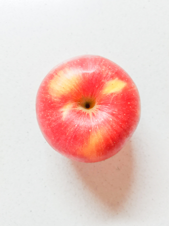 Ripe red apple on the white marble table. Top view