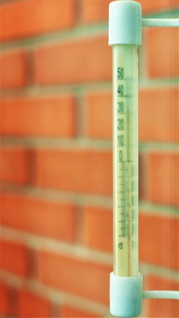 The outside temperature of the thermometer is made of plastic, hanging on the window.の写真素材