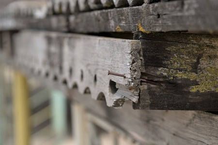 Rusty nail in an old wooden carved plank.