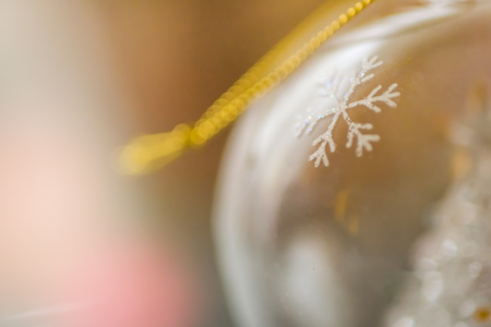 blurred empty glass Christmas ball with a snowflake and gold thread, macro shot.の写真素材