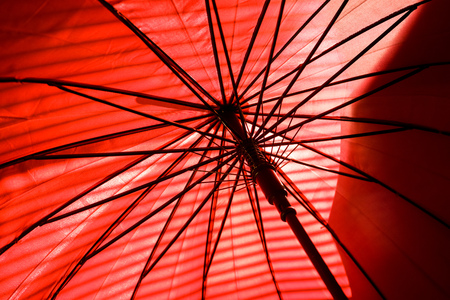 Inside red umbrella and sunlight with shadow, Sunshine through parasolの写真素材