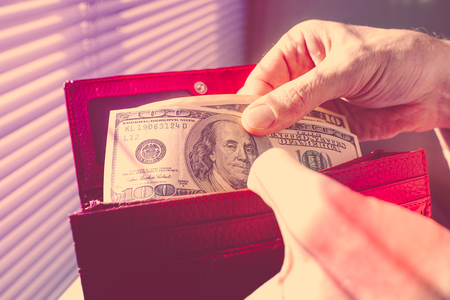 Male hands counting money in a purse.の写真素材