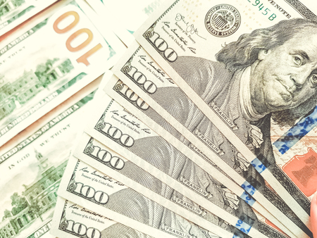 One hundred dollar bills on the table as background
