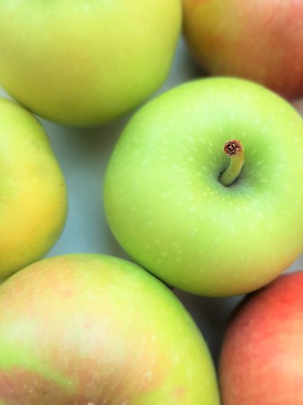 fresh apples of different colors on the table.の写真素材