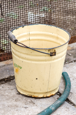 An old iron bucket stands in a rural yard.の写真素材