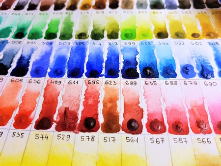 Watercolor palette with a samples and numbers of paint on paperの写真素材