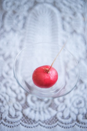 One ripe radish in a glass on a beautiful white tablecloth.の写真素材