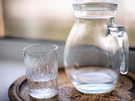 Jug of water and a glass in a tray closeupの写真素材