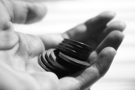 nine coins are in the human palm, bw photo.の写真素材