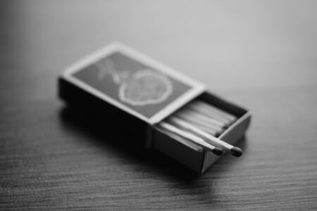 open cardboard box with matches on the table, black and white photographyの写真素材
