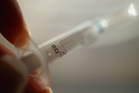 syringe in female hand, macro photo with selective focus.の写真素材