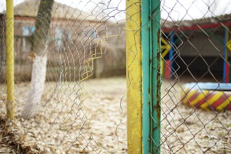 Old torn mesh fence. Selective focus. Autumn moodの写真素材