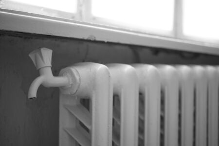 White iron radiator with tap, winter window, central heating in the roomの写真素材