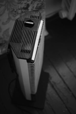 Retro electric heater Ugolek in the room, bw photo