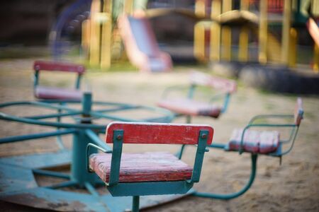 Playground with an old carousel in the sand closeup