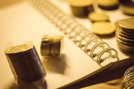 Collection of golden metal money on the notebook paperの写真素材