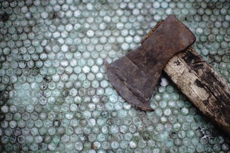 Old ax on the table with plastic wrap, copy space