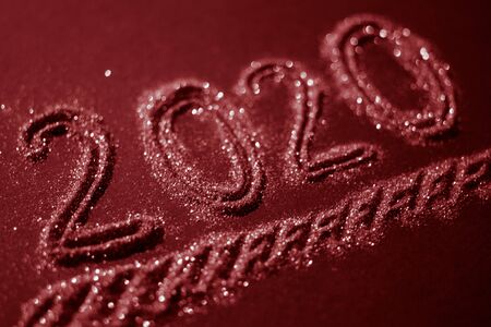 Christmas background with a flickering inscription 2020, red tone.