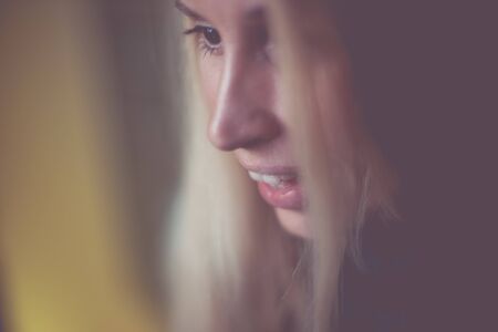 Happy talking with a smile young blond woman portrait, side view, art selective focus