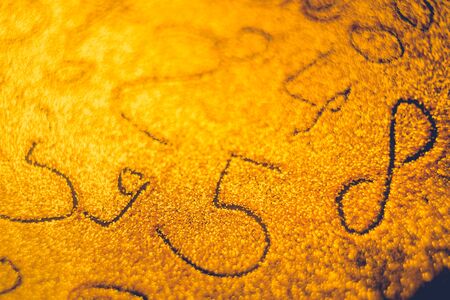 Different numbers painted on shiny sand, a numerical background on goldの写真素材