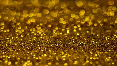 Golden shiny sand, gold sparkles blurred backgroundの写真素材