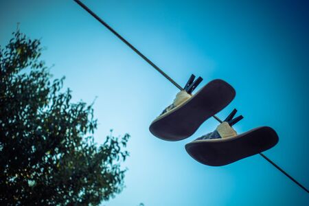 Home slippers are dried on a clothesline with clothespins, background sky and treeの写真素材
