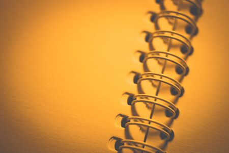 paper in an open spiral notebook, closeup photo, yellow warm toneの写真素材