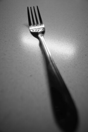 big modern fork on the table, bw photo.の写真素材