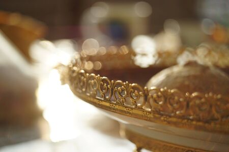 Beautiful venetian plate with carved golden patterned side, close-up, sweet sunny tableの写真素材