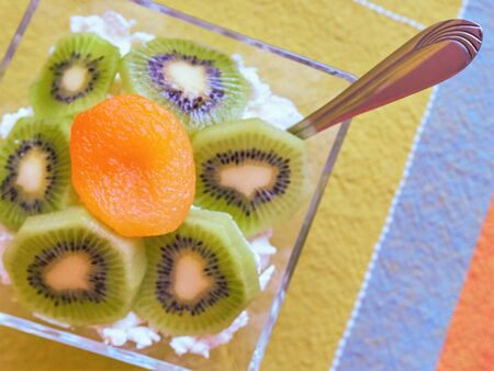 Dessert with cottage cheese, kiwi and dried apricot in a glass bowl, top viewの写真素材