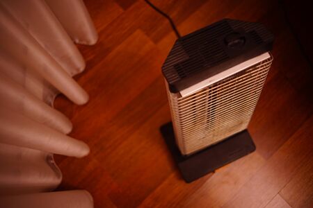Retro electric heater Ugolek in the room on parquet floor.