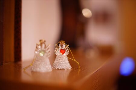 Two transparent statuettes of small angels on the mantelpiece.