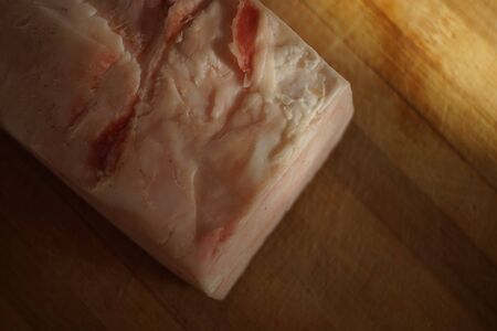 A whole large piece of lard lies on the table, top view