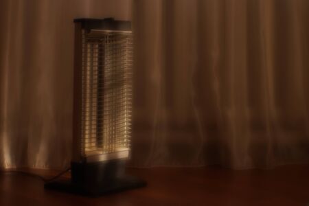 Vintage electric heater Ugolek in living room. Selective focus.の写真素材