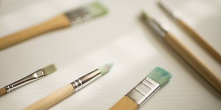 Used different brushes with wooden handles on white textured paper.の写真素材
