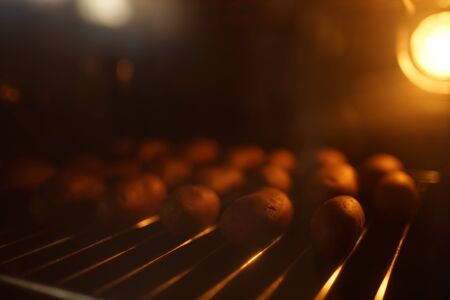 The whole potato in the peel is baked on the grill in the oven. Brown warm lightの写真素材