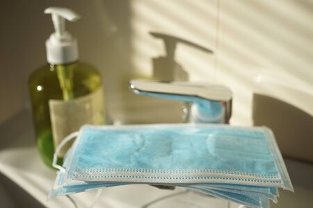 Blue medical masked on the tap in the bathroom. Side view, close upの写真素材