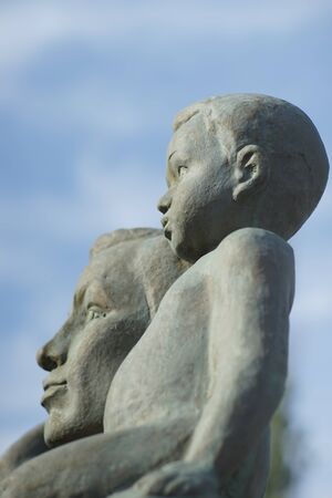faces child and man, monument marble, close-up on blue sky background.の写真素材
