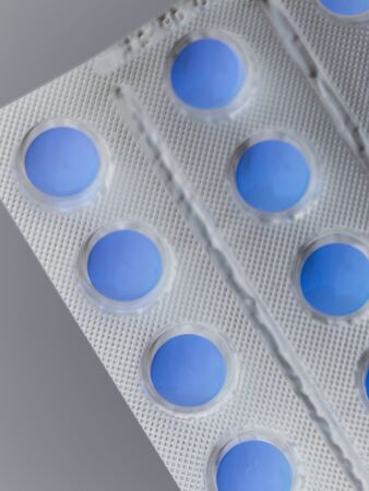 Blister with blue vitamins or pills, macro photo, inversion