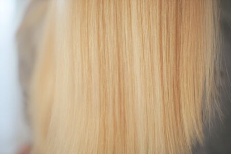 Beautiful blonde hair on blurred female back background.の写真素材