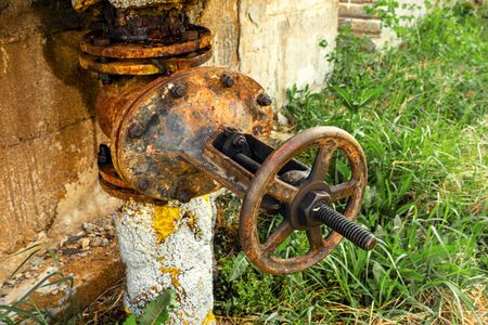 Old rusty round tap of tank closeup, outdoor.の写真素材
