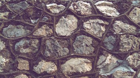 Wall of large stones with thick seams, rubble background.