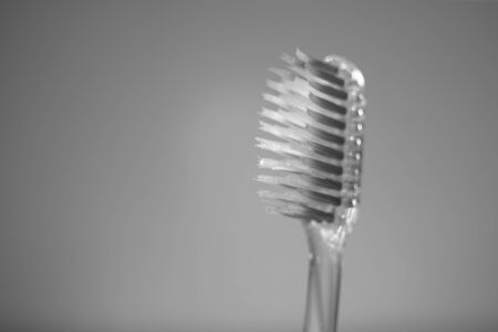 Transparent plastic toothbrush with old bristles, side view, copy space