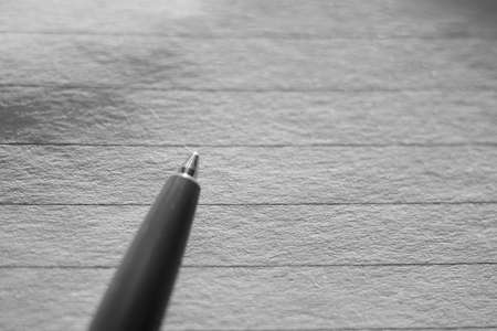 Ballpoint pen on notebook paper in line. Top view. Black and white photoの写真素材